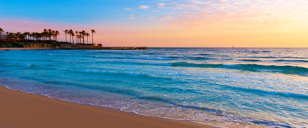 Abahana Villas - Sonnenuntergang am Strand von Arenal in Jávea mit entspannter Atmosphäre.